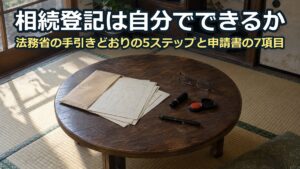 和室のちゃぶ台に広げた古い書類の束と、認印・朱肉・ボールペン・老眼鏡
